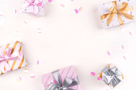 Several gift boxes with bows and confetti on a white background. Flat lay composition. Birthday, christmas, wedding or another holiday concept.の写真素材