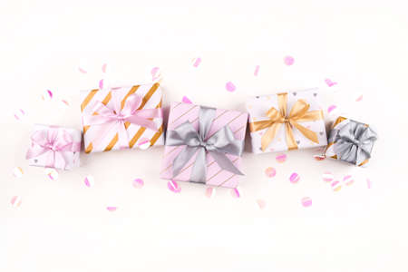 Set of gift boxes with bows and confetti on a white background. Flat lay composition. Birthday, christmas, wedding or another holiday concept.の写真素材