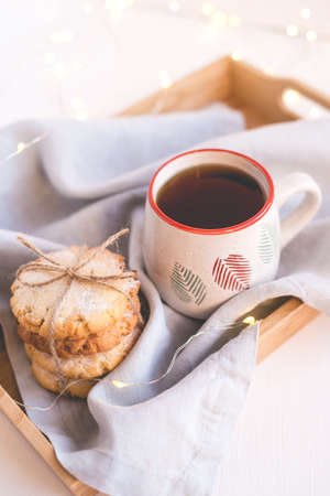 Fresh cookies and cup of tea on a wooden tray. Holiday concept. Close up.の写真素材