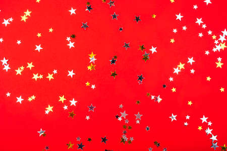 Golden and silver stars on red background. Flat lay, top view.の写真素材