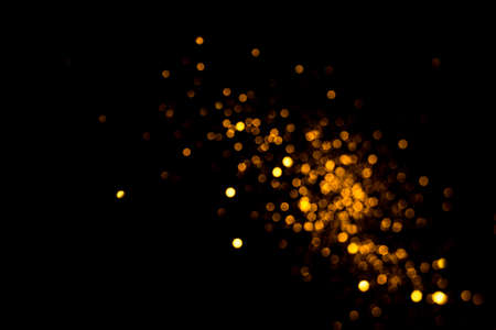 Golden abstract bokeh on black background. Holiday conceptの写真素材