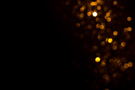 Golden abstract bokeh on black background. Holiday conceptの写真素材