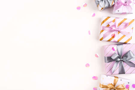 Set of gift boxes with bows and confetti on a white background. Flat lay composition. Birthday, christmas, wedding or another holiday concept.の写真素材