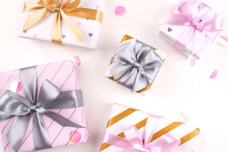 Set of gift boxes with bows and confetti on a white background. Flat lay composition. Birthday, christmas, wedding or another holiday concept.の写真素材
