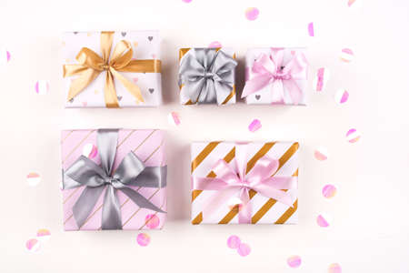 Set of gift boxes with bows and confetti on a white background. Flat lay composition. Birthday, christmas, wedding or another holiday concept.の写真素材