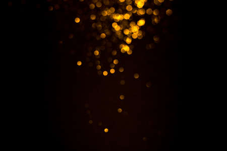 Golden abstract bokeh on black background. Holiday conceptの写真素材