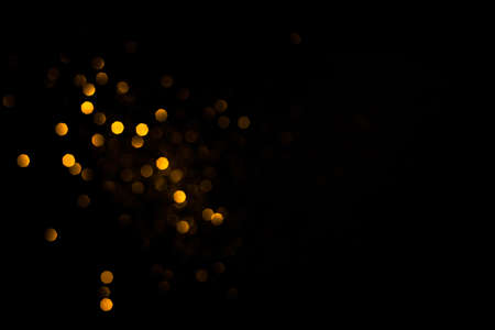 Golden abstract bokeh on black background. Holiday conceptの写真素材