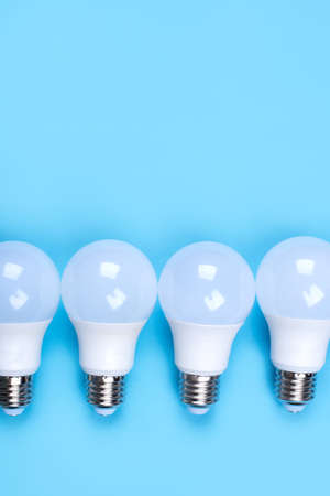 Several LED bulb on blue background. Saving energy concept. Ftat lay, top view, copy space.の写真素材