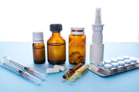 Tablets, pack of medicines with medicine bottles on a blue background. Pharmacy theme.の写真素材