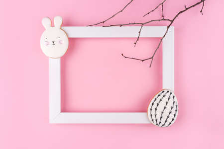 Easter egg and bunny cookies with white frame on pink background. Place for your text. Spring holiday.の写真素材