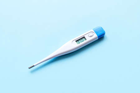 Close-up medical thermometer on blue background. Treatment concept.