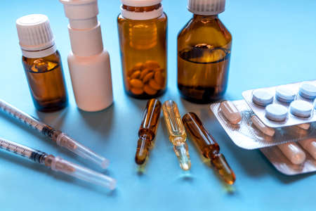 Tablets, pack of medicines with medicine bottles on a blue background. Pharmacy theme.の写真素材