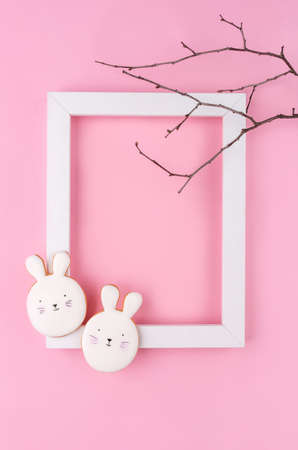 Easter egg and bunny cookies with white frame on pink background. Place for your text. Spring...