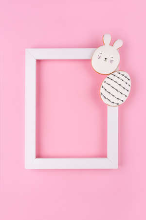 Easter eggs and bunny cookies with white frame on pink background. Place for your text. Spring holiday.の写真素材