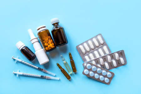 Tablets, pack of medicines with medicine bottles on a blue background. Pharmacy theme.