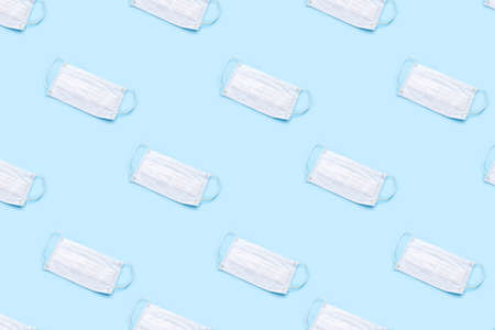 Disposable medical mask on blue background. Healthcare and medical concept.の写真素材