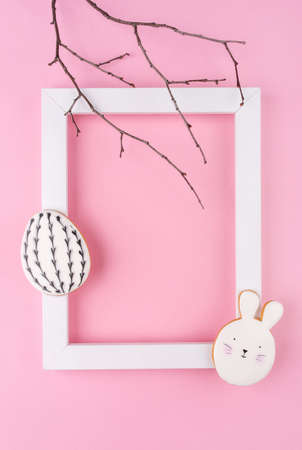 Easter egg and bunny cookies with white frame on pink background. Place for your text. Spring holiday.の写真素材