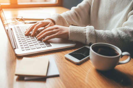 Young woman working in a home office on her laptop computer. Remote work concept.の写真素材