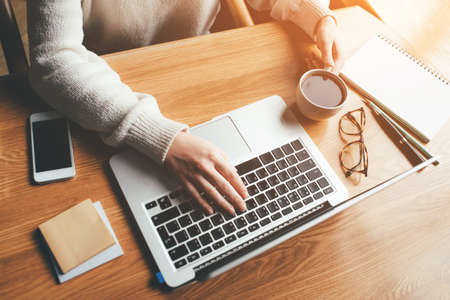 Young woman working in a home office on her laptop computer. Remote work concept.の写真素材