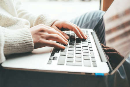 Young woman working in home on her laptop computer. Remote work concept.の写真素材