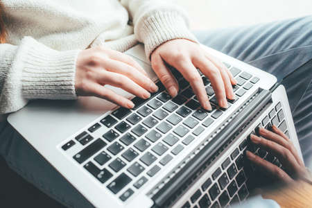 Young woman working in home on her laptop computer. Remote work concept.の写真素材