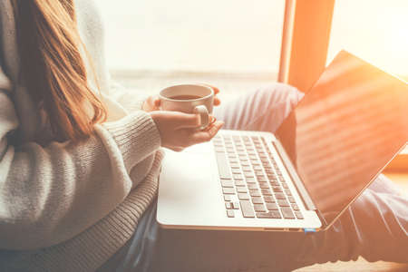 Young woman working in home on her laptop computer. Remote work concept.の写真素材