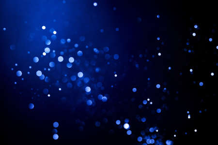 Abstract dark background with glowing blue particles.の写真素材