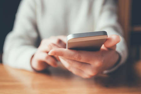 Womens hands use a smartphone for online shopping, social networking, or remote work. Close up image.の写真素材