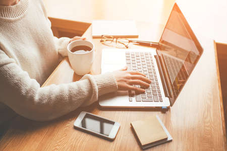 Young woman working in a home office on her laptop computer. Remote work concept.の写真素材