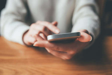 Womens hands use a smartphone for online shopping, social networking, or remote work. Close up image.の写真素材