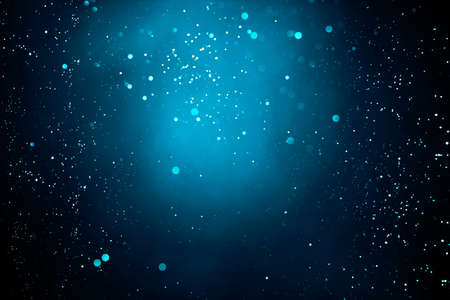 Abstract dark background with glowing turquoise particles.の写真素材
