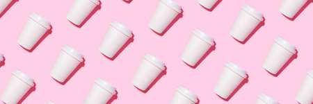 Pattern of disposable coffee cups on a pink background. Flat lay.の写真素材