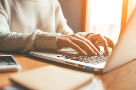 Young woman working in home on her laptop computer. Remote work concept.の写真素材