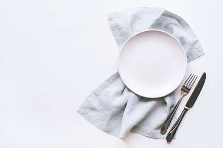 An empty plate and Cutlery on a white table. Top view. Copy space for text.の写真素材