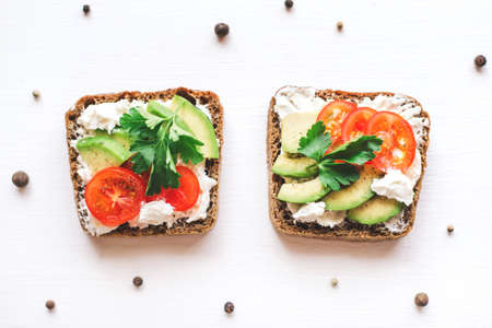 Avocado toast with cherry tomatoes and feta cheese on plate. Healthy eating concept.の写真素材