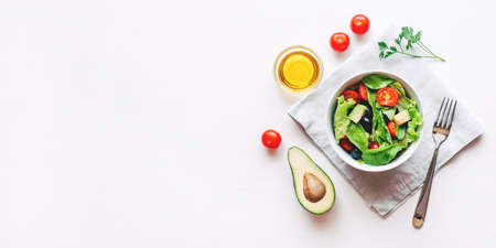 Fresh salad of avocado, cherry, arugula and olives made at home. Vegan food. The concept of healthy eating. Top view.の写真素材