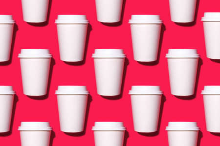 Pattern of disposable coffee cups on a red background. Flat lay.の写真素材