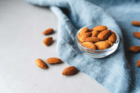 Peeled almonds in a glass bowl on gray napkin.の写真素材