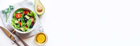 Fresh salad of avocado, cherry, arugula and olives made at home. Vegan food. The concept of healthy eating. Top view.の写真素材