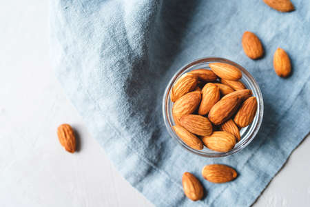 Peeled almonds in a glass bowl on gray napkin.の写真素材