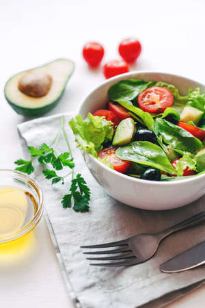 Fresh salad of avocado, cherry, arugula and olives made at home. Vegan food. The concept of healthy eating. Front view.の写真素材