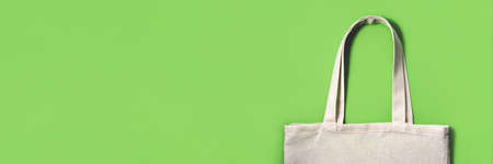 Fabric eco-bag on green background. Flat lay, top view. Eco friendly concept.の写真素材