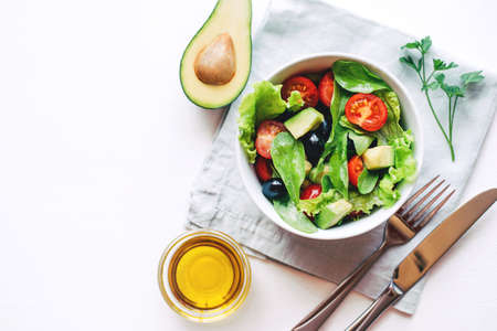 Fresh salad of avocado, cherry, arugula and olives made at home. Vegan food. The concept of healthy eating. Top view.の写真素材