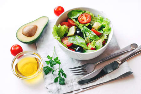 Fresh salad of avocado, cherry, arugula and olives made at home. Vegan food. The concept of healthy eating. Front view.の写真素材