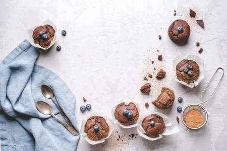 Homemade fresh chocolate muffins with berries and chocolate pieces. Top view. Copy space for text.の写真素材