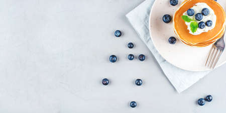 A stack of pancakes with fresh blueberries and cheesecream. Top view. Copy space for text.の写真素材