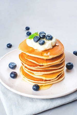 A stack of pancakes with fresh blueberries and cheesecream.の写真素材