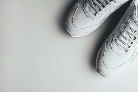 Gray sneakers on a gray background. A trending monochrome image for your design. Copy space for text.の写真素材