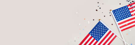 Festive background with US flags and confetti in the shape of stars. US independence day.の写真素材