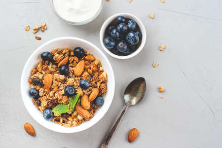 Baked granola with yogurt and blueberries on a gray table. Top view.の写真素材